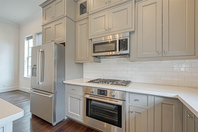 5101 Allen St, Houston, TX 77007 - kitchen with stainless steel appliances, dark wood-style flooring, light countertops, decorative backsplash, and baseboards