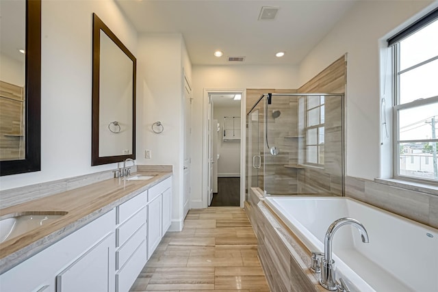 5101 Allen St, Houston, TX 77007 - bathroom with a garden tub, double vanity, a stall shower, recessed lighting, and baseboards