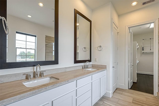 5101 Allen St, Houston, TX 77007 - full bathroom with double vanity, recessed lighting, wood finished floors, and a shower