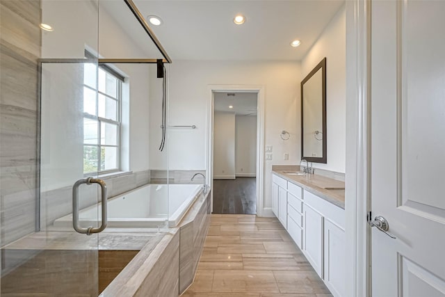 5101 Allen St, Houston, TX 77007 - bathroom featuring a bath, recessed lighting, double vanity, and wood finished floors