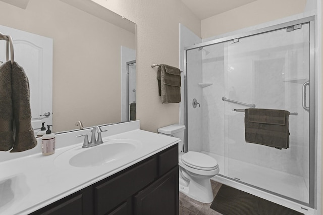 bathroom with toilet, a stall shower, and vanity