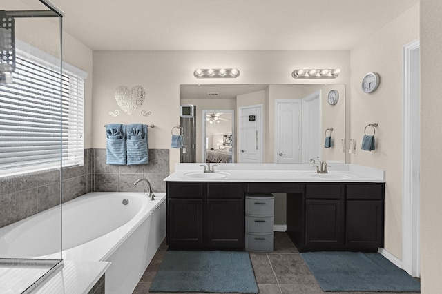 bathroom featuring double vanity, a garden tub, a sink, and connected bathroom