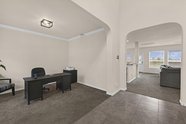 office area with arched walkways, dark colored carpet, baseboards, and ornamental molding