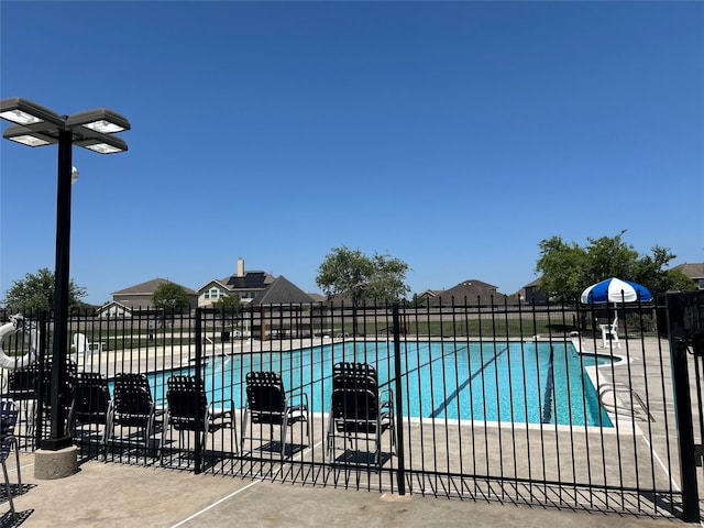 pool with a patio area and fence