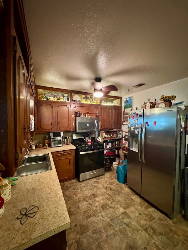 447 Fm 2540 N, Van Vleck, TX 77482 - kitchen featuring appliances with stainless steel finishes, a sink, a ceiling fan, light countertops, and a textured ceiling