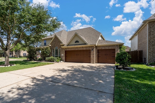 view of front facade featuring brick siding, driveway, an attached garage, and roof with shingles