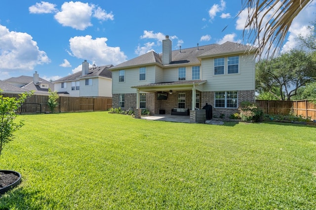 back of property with brick siding, a patio area, and a chimney