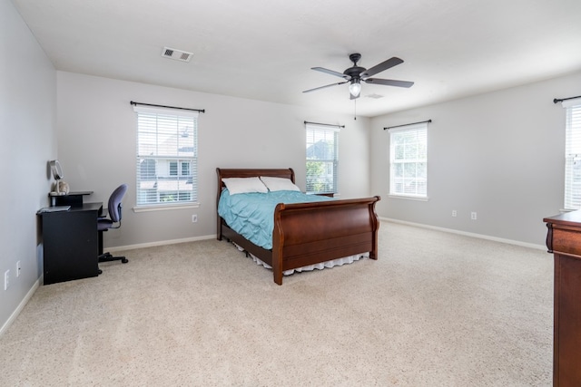 carpeted bedroom featuring baseboards, ceiling fan, and a desk