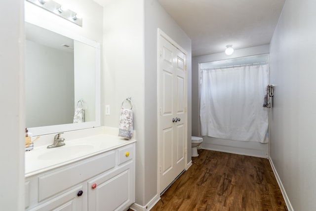 full bath featuring toilet, wood finished floors, vanity, shower / bath combination with curtain, and baseboards