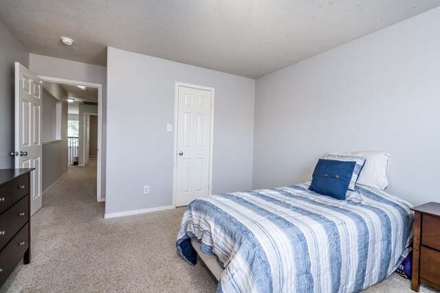 bedroom with light colored carpet and baseboards