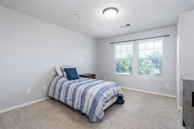 bedroom with light carpet and baseboards