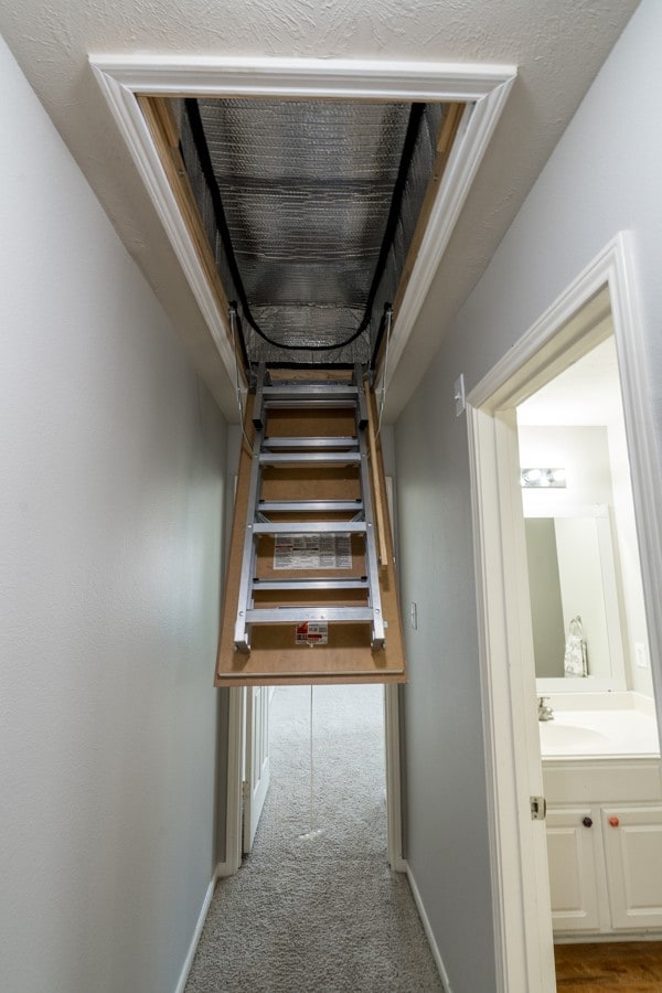 hallway with carpet, a sink, and baseboards