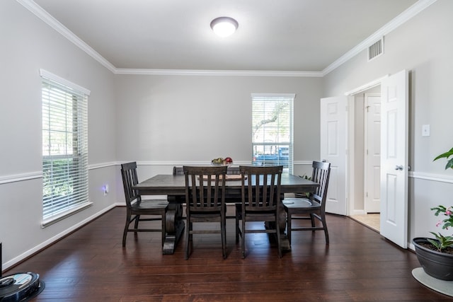 dining space featuring crown molding, wood finished floors, and baseboards