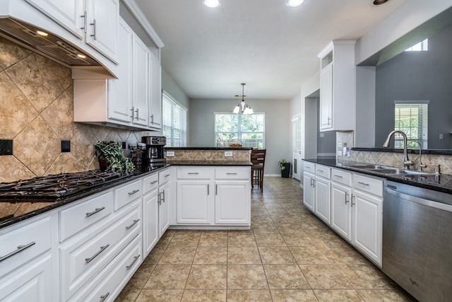 kitchen with dishwasher, a sink, under cabinet range hood, backsplash, and a peninsula
