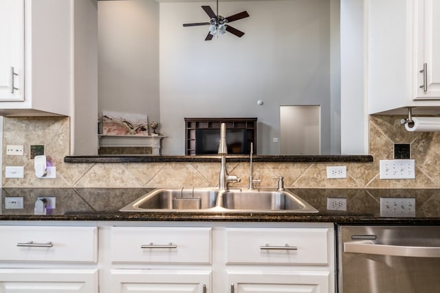 kitchen featuring stainless steel dishwasher, ceiling fan, white cabinetry, dark stone counters, and backsplash