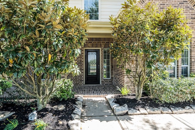 view of exterior entry featuring brick siding