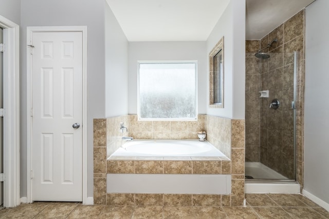 full bathroom featuring a stall shower, tile patterned flooring, and a garden tub