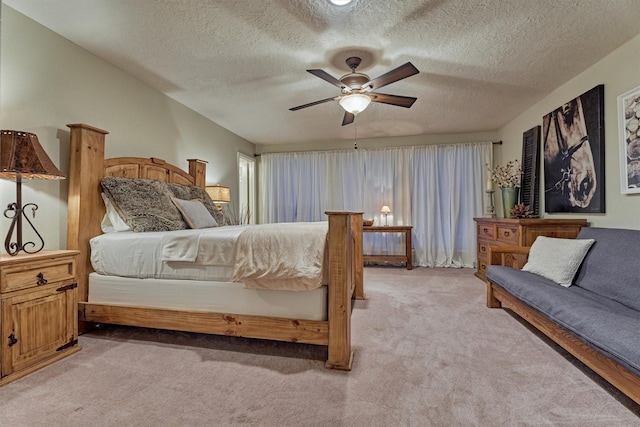 bedroom featuring light carpet, a ceiling fan, and a textured ceiling
