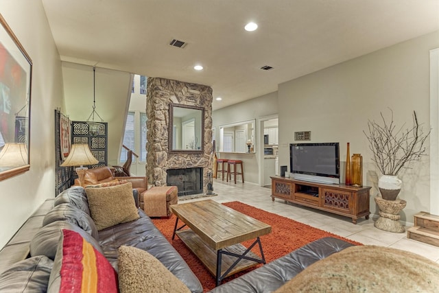 living room featuring visible vents, a stone fireplace, recessed lighting, and light tile patterned flooring