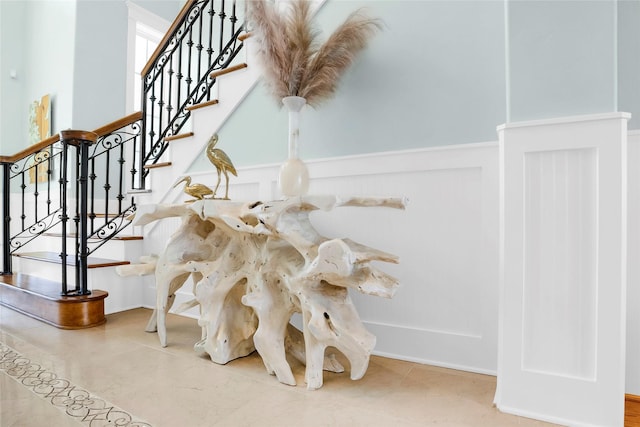 20710 E Sunset Bay Dr, Galveston, TX 77554 - stairway with a decorative wall, tile patterned floors, and wainscoting