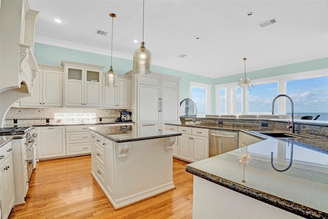 20710 E Sunset Bay Dr, Galveston, TX 77554 - kitchen with stainless steel appliances, backsplash, a kitchen island, a sink, and visible vents
