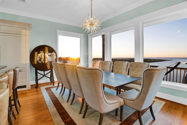 20710 E Sunset Bay Dr, Galveston, TX 77554 - dining room featuring baseboards, crown molding, light wood-style floors, and a notable chandelier