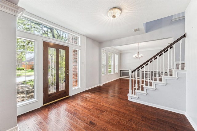 entryway featuring visible vents, baseboards, wood-type flooring, a notable chandelier, and stairs