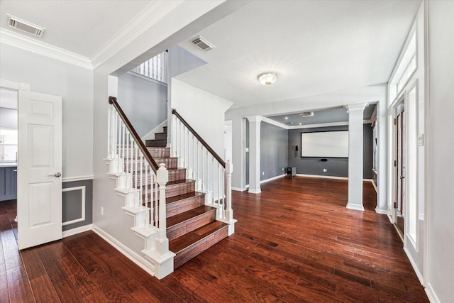 staircase featuring visible vents, ornate columns, wood-type flooring, and crown molding