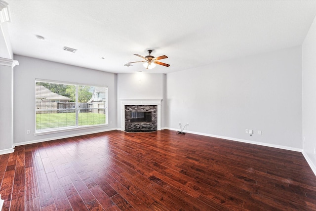 unfurnished living room featuring a fireplace, a ceiling fan, visible vents, baseboards, and wood finished floors