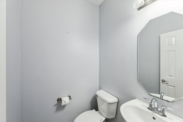 half bathroom featuring toilet and a sink