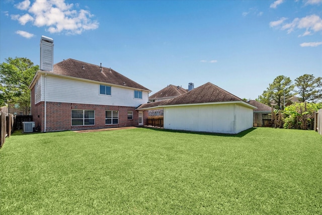 rear view of property with brick siding, a fenced backyard, a yard, and central air condition unit
