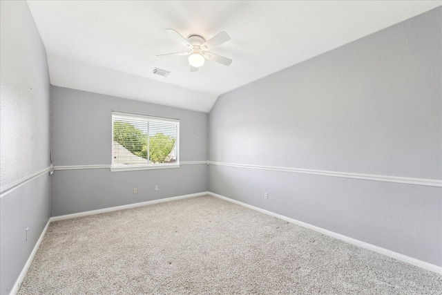 unfurnished room featuring ceiling fan, visible vents, carpet, baseboards, and lofted ceiling