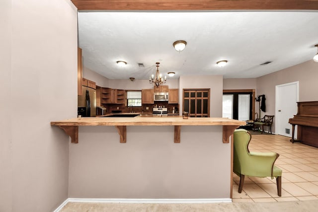 3810 Peters San Felipe Rd, Sealy, TX 77474 - kitchen featuring an inviting chandelier, light countertops, a peninsula, stainless steel appliances, and a breakfast bar area