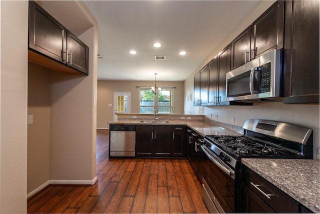 17035 Wilthorne Gardens Ct, Houston, TX 77084 - kitchen with dark wood finished floors, dark brown cabinetry, stainless steel appliances, and a sink