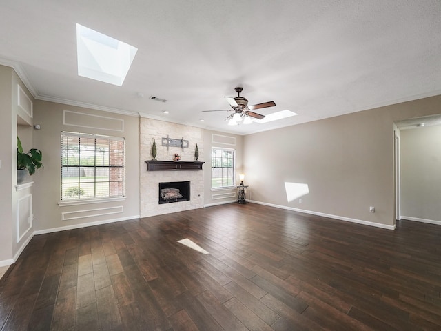 2202 Canterbury Ct, Deer Park, TX 77536 - unfurnished living room with a skylight, dark wood-style floors, a stone fireplace, baseboards, and ornamental molding