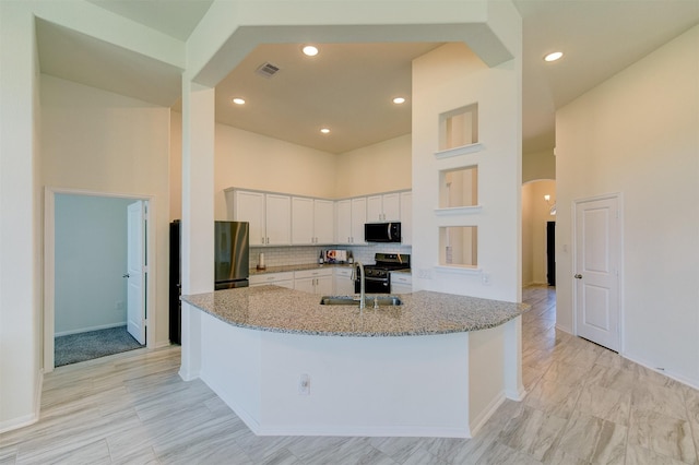 12006 Wooden Mill Ln, Santa Fe, TX 77510 - kitchen featuring black microwave, arched walkways, visible vents, stainless steel gas range, and a sink