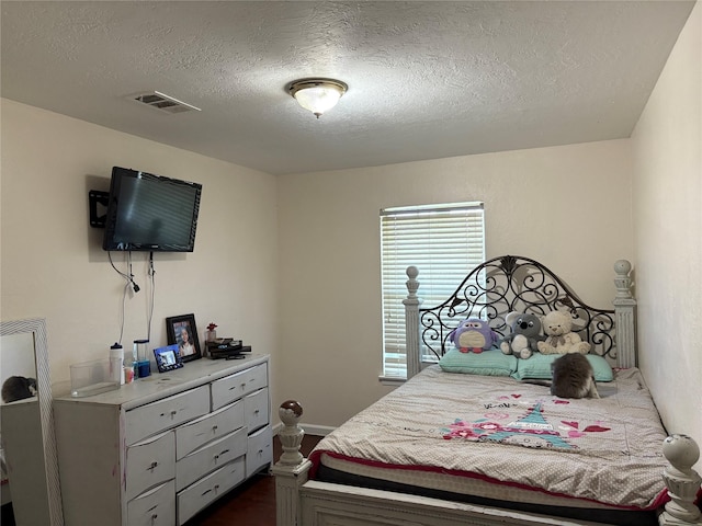 431 Crockett St, Channelview, TX 77530 - bedroom featuring dark wood-type flooring, a textured ceiling, and visible vents
