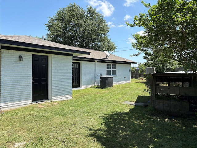 431 Crockett St, Channelview, TX 77530 - rear view of property featuring brick siding, a yard, central AC unit, and fence