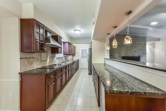 10607 Longmont Dr, Houston, TX 77042 - kitchen with wall chimney range hood, black electric stovetop, freestanding refrigerator, dark stone countertops, and light tile patterned floors