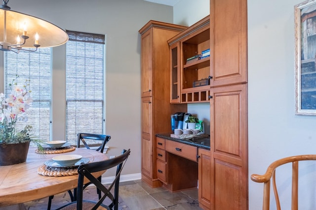 dining area featuring a chandelier and baseboards