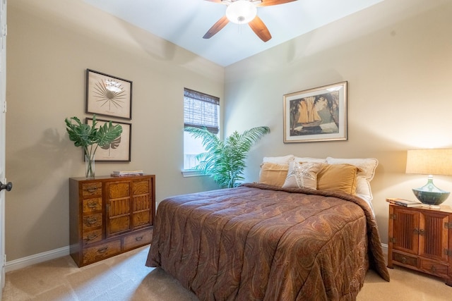 bedroom featuring light carpet, baseboards, and ceiling fan