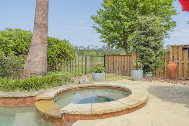 view of swimming pool with an in-ground hot tub and fence