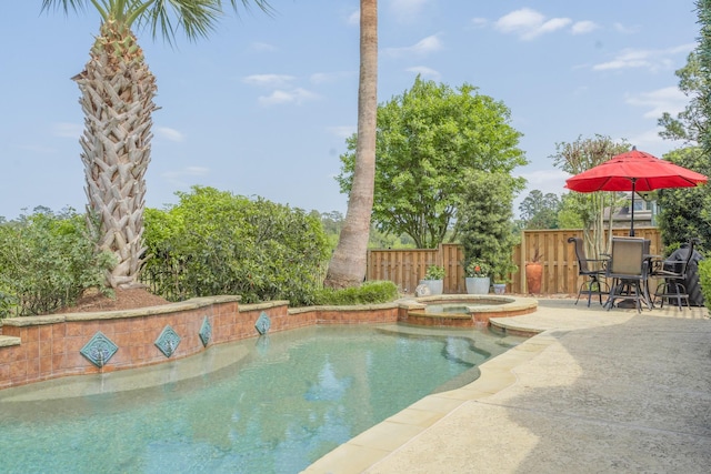 view of pool featuring a pool with connected hot tub, fence, and a patio area