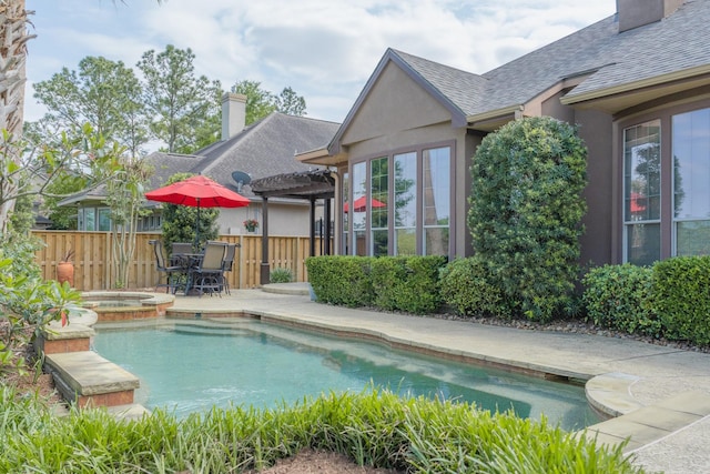 view of swimming pool featuring fence, a pool with connected hot tub, and a patio