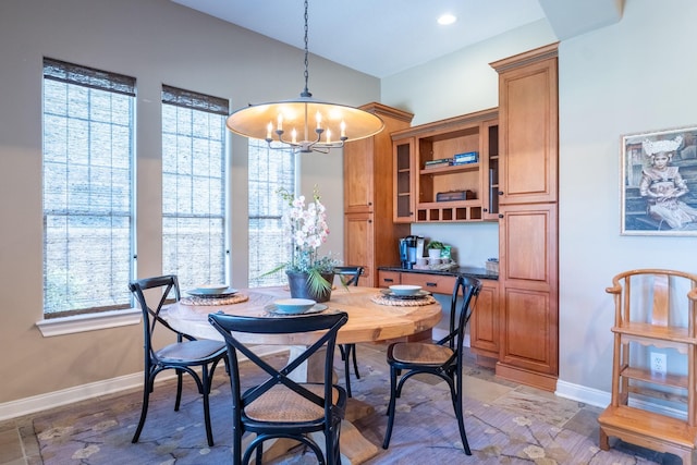 dining room with a chandelier and baseboards