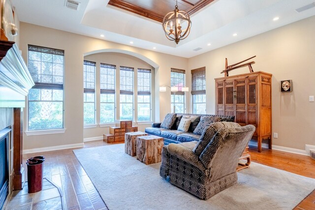 living area featuring recessed lighting, a chandelier, light wood-style floors, baseboards, and a tray ceiling