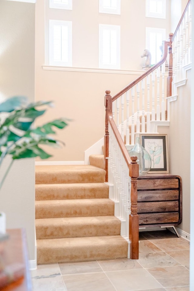 stairway featuring healthy amount of natural light and baseboards