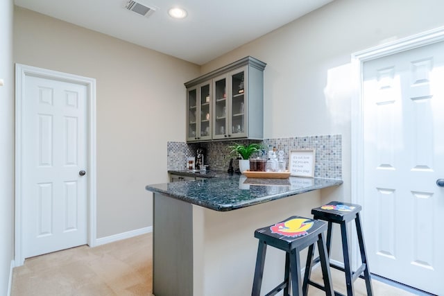 indoor wet bar featuring light carpet, tasteful backsplash, baseboards, and recessed lighting