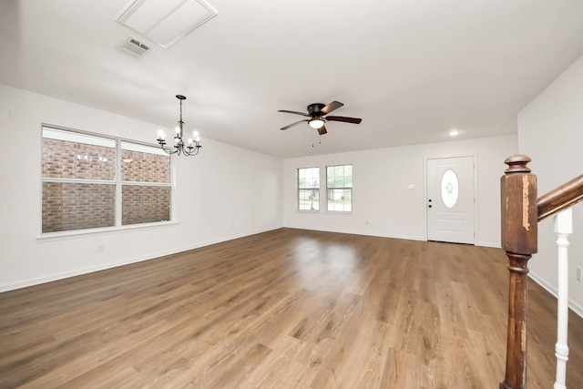 foyer entrance featuring stairway, ceiling fan with notable chandelier, baseboards, visible vents, and wood finished floors