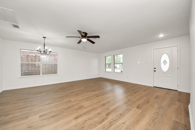 foyer with light wood finished floors, ceiling fan with notable chandelier, visible vents, and baseboards